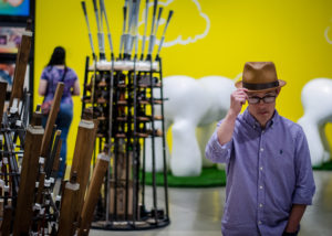 artist tips his fedora hat in an art gallery