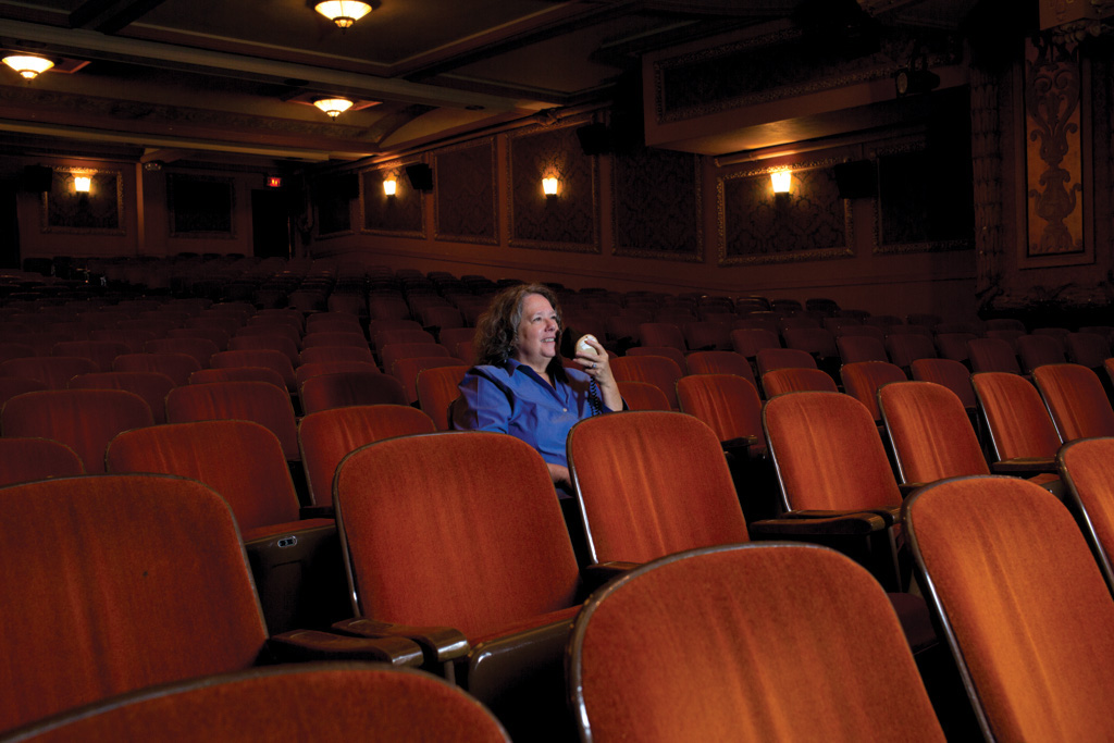 Celia Hughes sits in a theatre ready to describe for blind and low vision guests