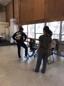 one dancer in a wheelchair with a stand-up dancer exchanging ideas of how to translate specific moves to different bodies. 