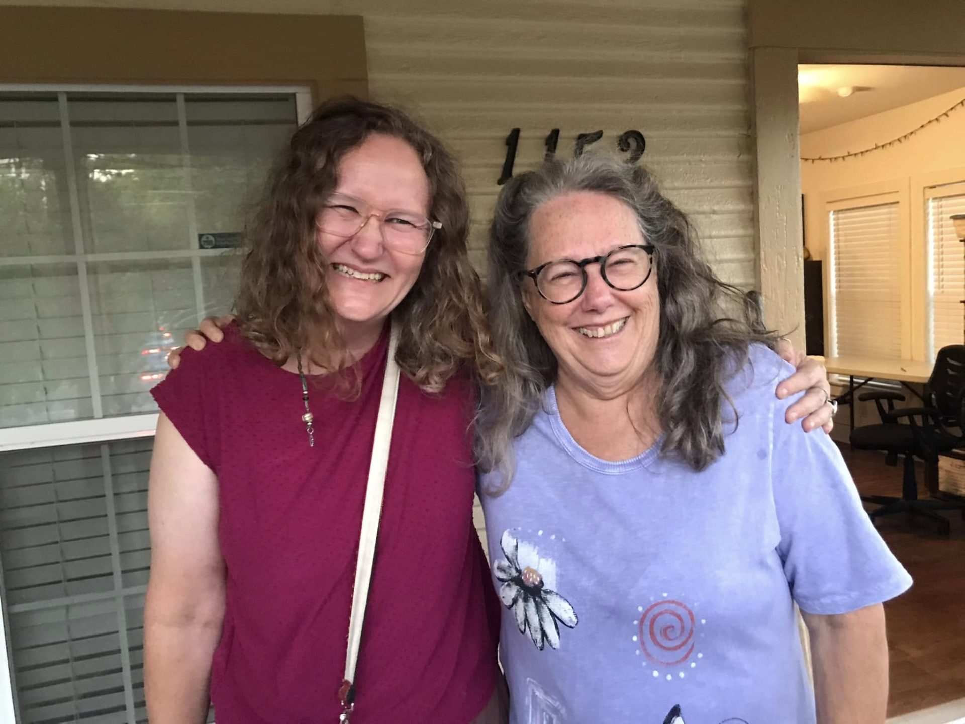 April Sullivan and Celia Hughes of Art Spark Texas smiling on the porch at the headquarters in the Rosewood neighborhood