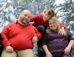 David and Terri, pose before a snowy forest backdrop with their son, Denver.