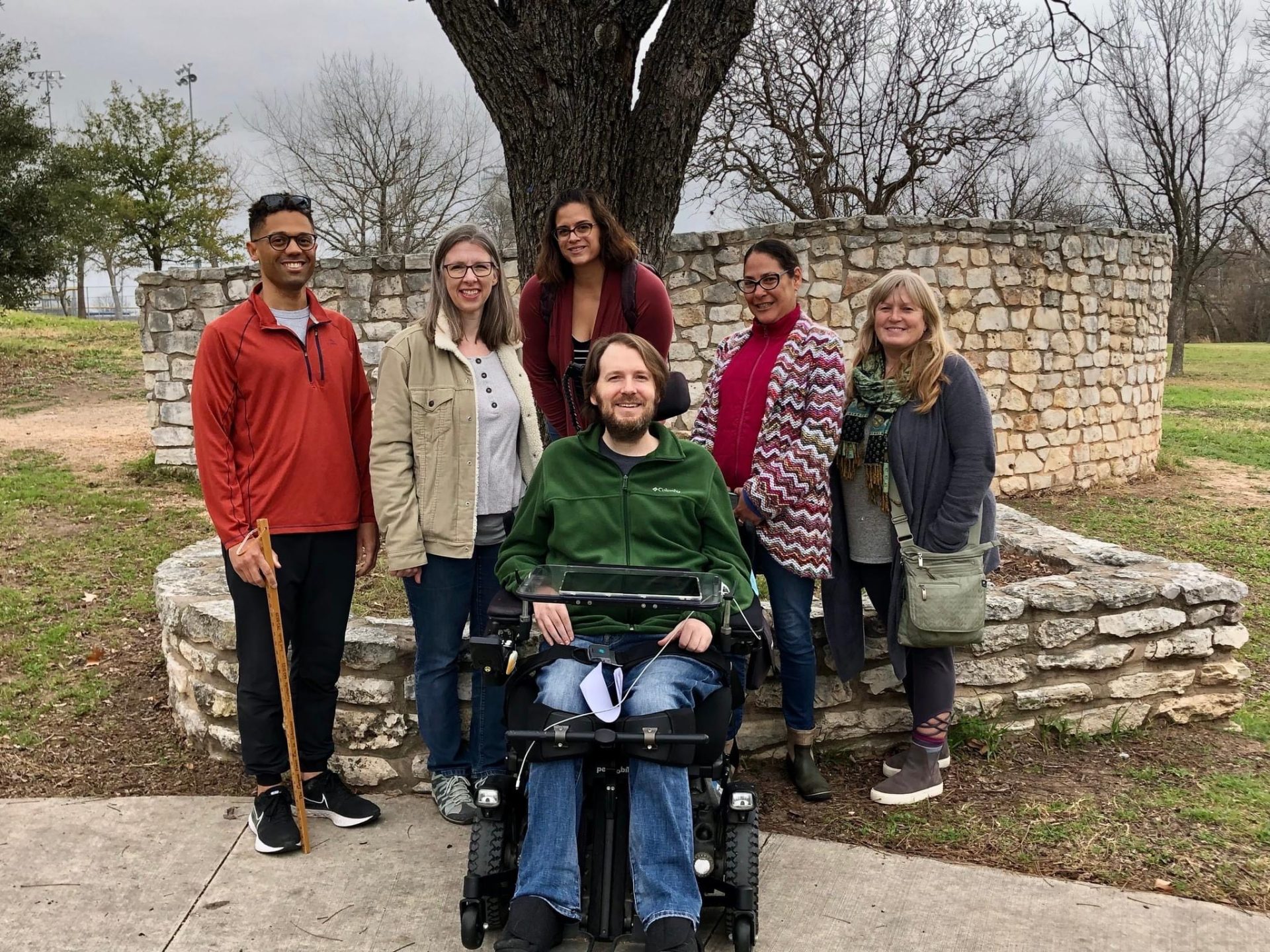 six volunteers with and without disabilities posing for a picture. One volunteer is holding a measuring stick.