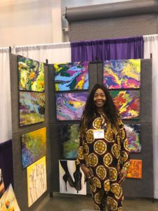 Artist standing in front of her booth