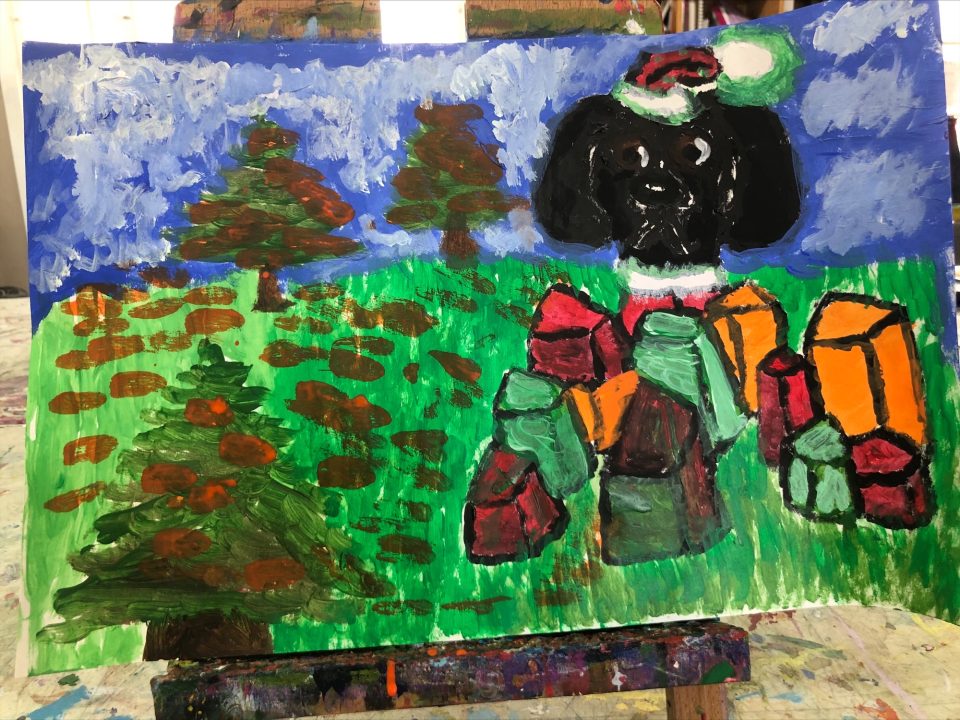 Painting by Yadira of Deja wearing a Santa Suit and hat surrounded by brightly-colored Christmas Presents. She sits on green grass below a cloudy blue sky with Christmas trees in the background and front left.