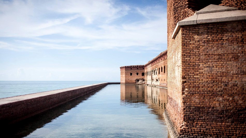 Brick fortress with water moat and ocean in the background