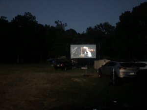 cars parked in front of portable movie screen
