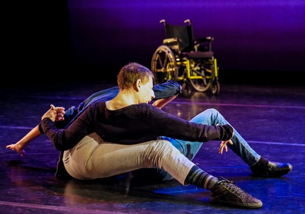 2 dancers come up to a sitting position after contact improvisation performance on indoor stage
