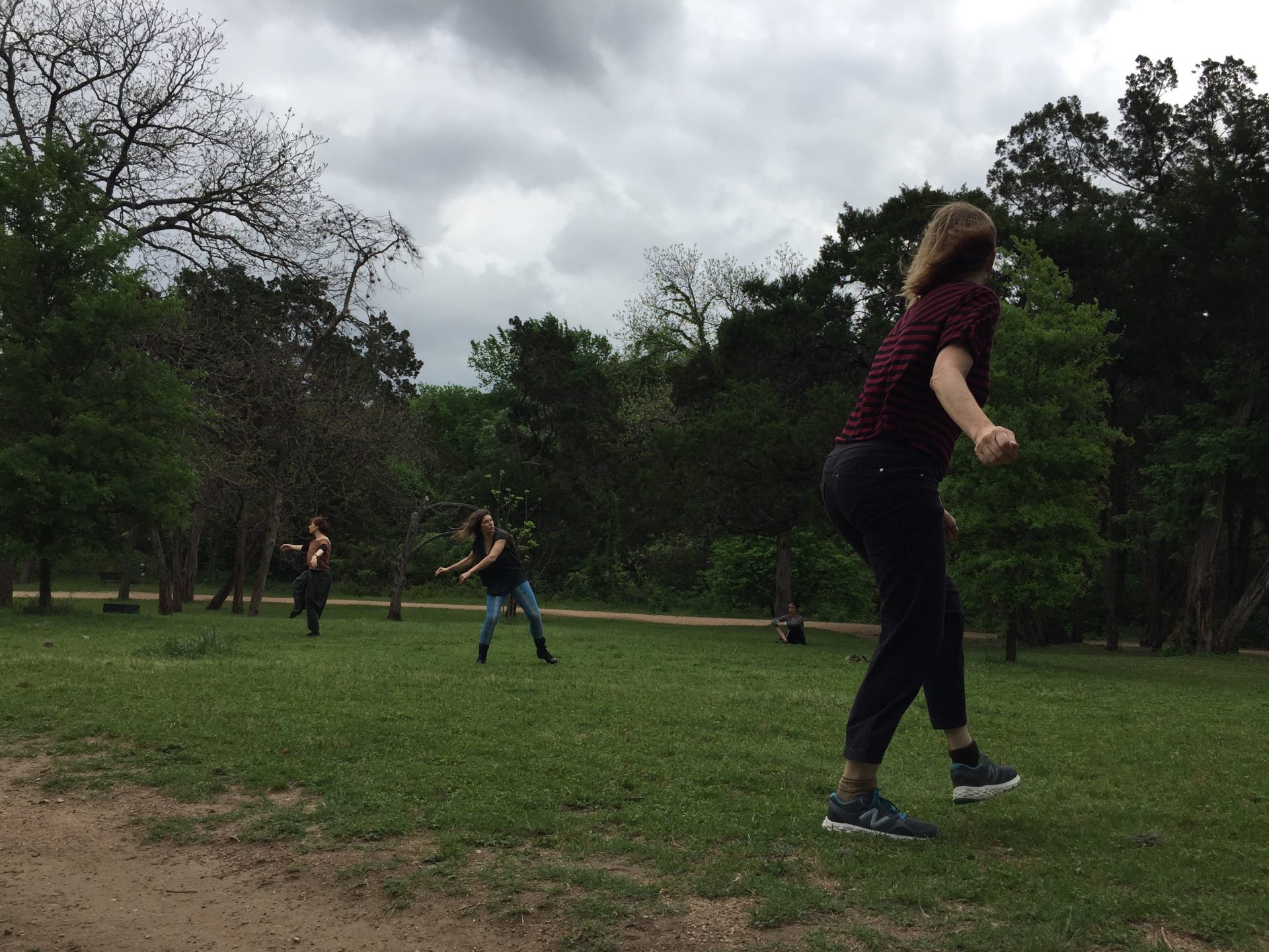three women dancing in a park