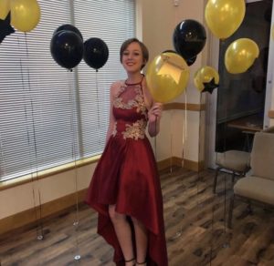 photo of Gillian in red dress holding a yellow balloon