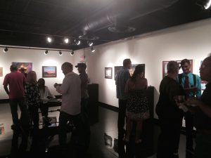 people mingle at an art gallery reception