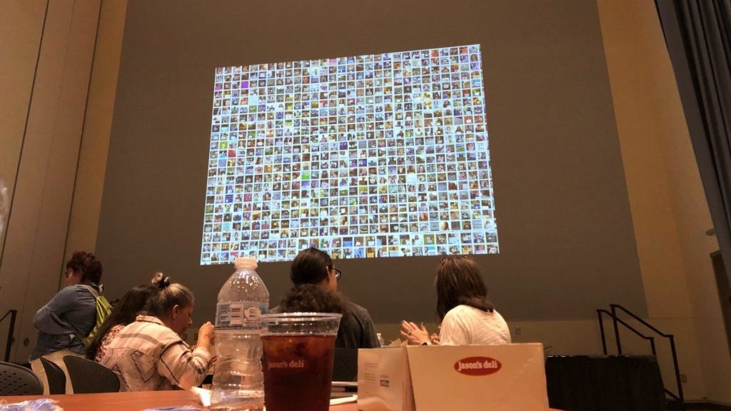 Conference projection screen shows a thousand thumbnails of people holding "narcolepsy not alone” signs
