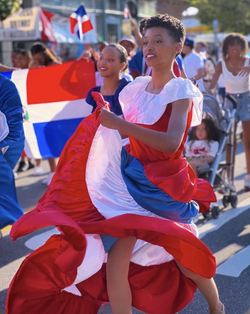 Emely Siri performing in a street parade wearing a traditional Dominican Republic Dress. 