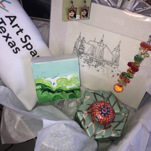 assorted gifts laid out in a box; gifts include a small painting, earings, oragami box, painted rock, and fine-line drawing.