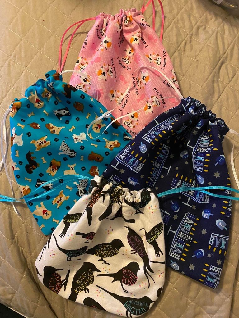 four hand-made draw string bags made with various fabric patterns. 