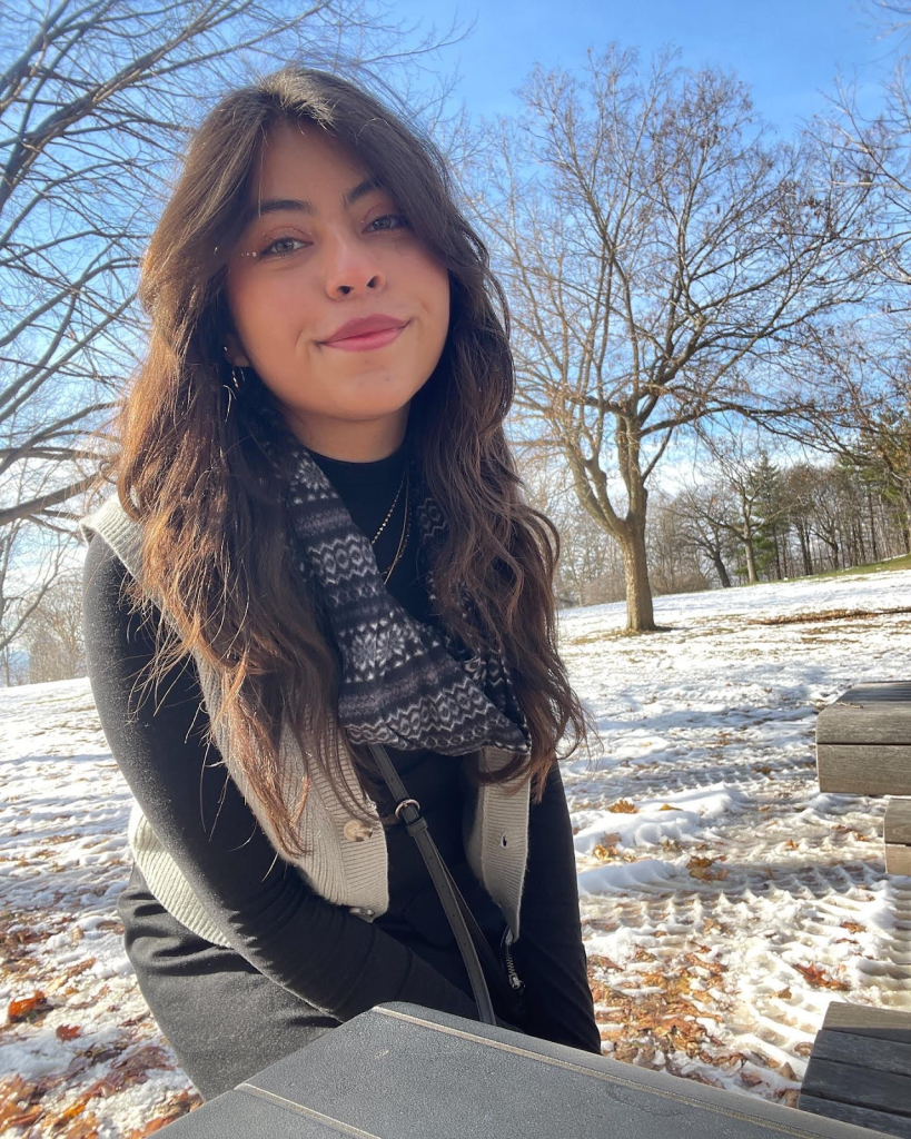 A headshot of Andrea Tovar outdoors on a sunny, snowy day. 