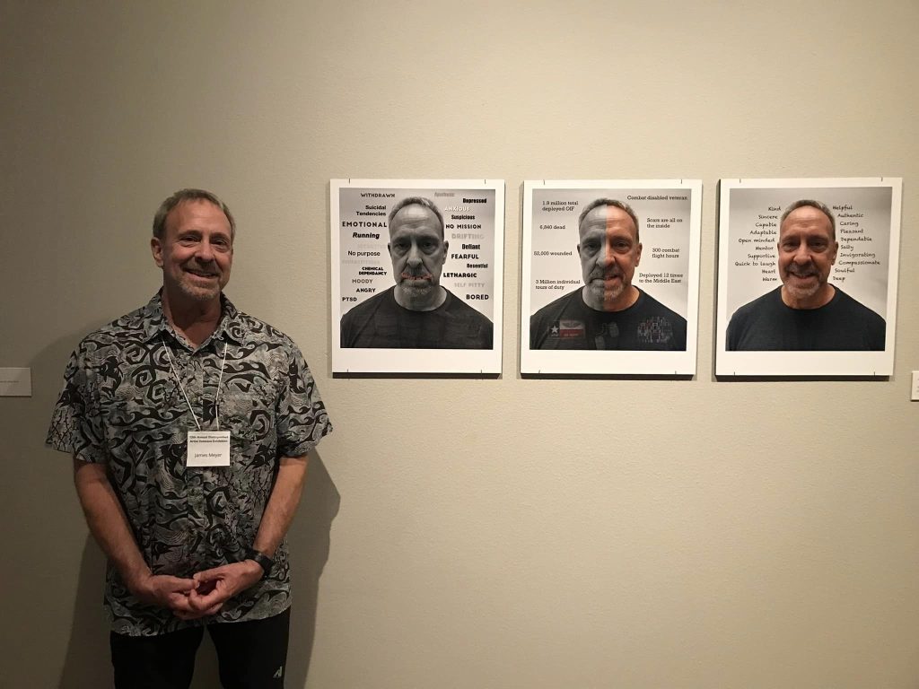 A photo of James posing with his triptych, “So Now I’m a Veteran.”