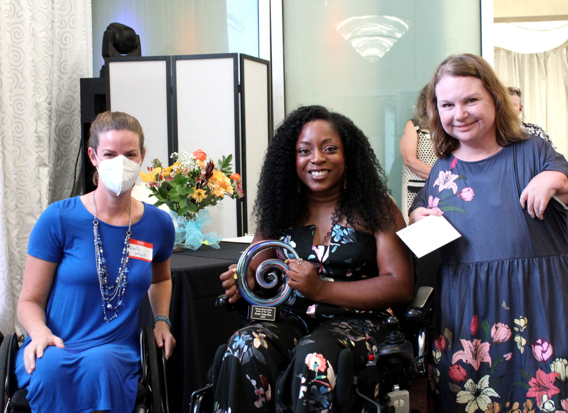 An awardee poses smiling with an art spark board member and a participant.