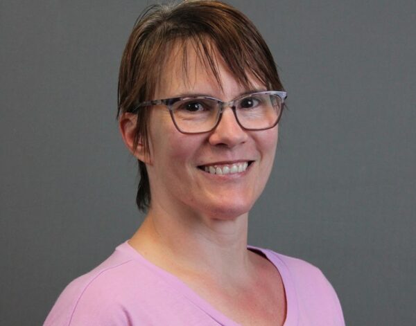 Photo of Lila Milam-Kast, a light-complexioned female with short hair and glasses