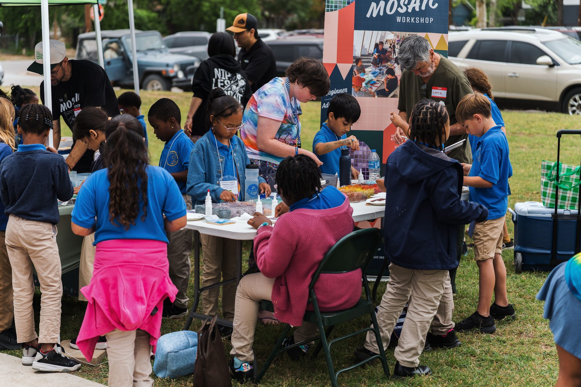 Students at Art in the Park at the Mosaix Workshop booth pop-up engaging in mosaic crafts at Art in the Park