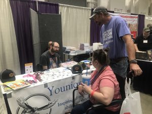 A vendor with two customers browsing their work.