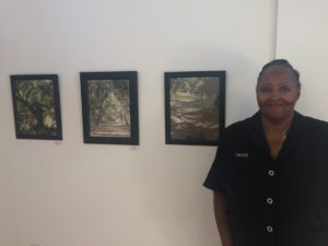 woman poses next to her art