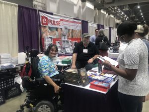 two people buy artwork from vendors at the abilities expo.