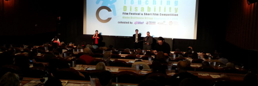 packed movie theatre, screen says "Cinema Touching Disability"
