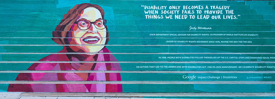 Painting of disability activist Judy Heumann on outdoor staircase with quote “disability only becomes a tragedy when society fails to provide the things we need to lead our lives"