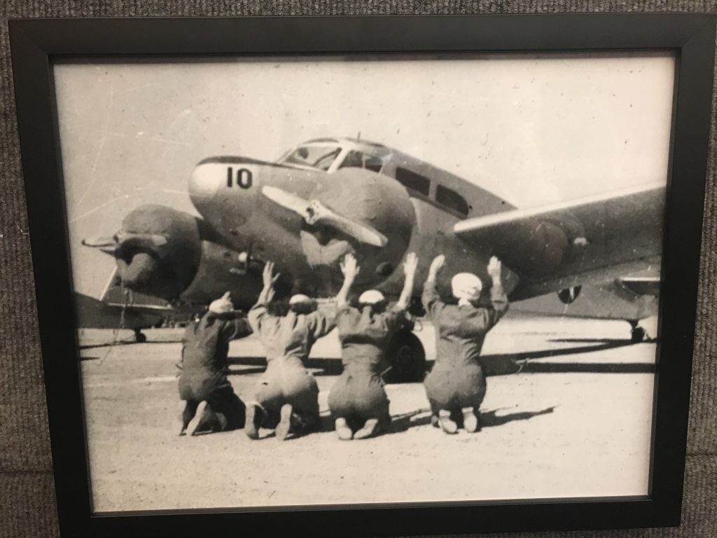 photo of women kneeling in reverence before an air force bomber
