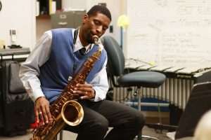 quamon plays saxophone in a classroom